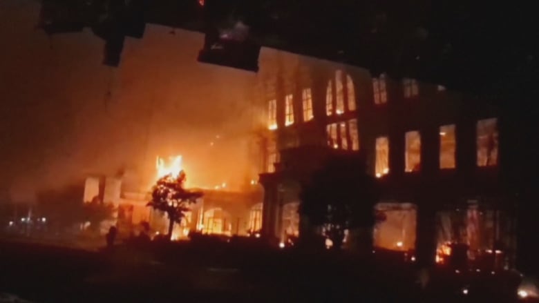 A night time photo of a fire burning in a large hotel. 